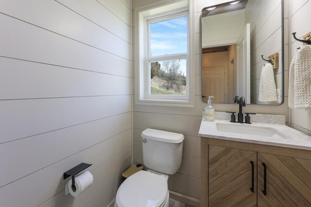 half bathroom featuring vanity and toilet