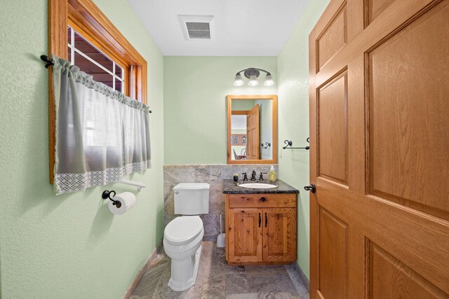 63626 Hannu Ln, Finlayson, MN 55735 - half bath with vanity, tile walls, toilet, marble look tiles, and wainscoting