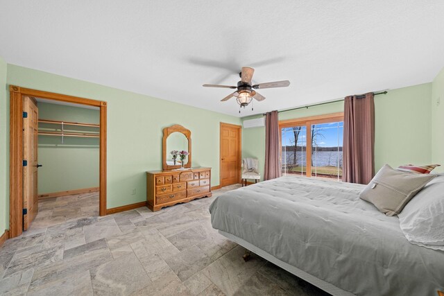 63626 Hannu Ln, Finlayson, MN 55735 - bedroom with stone finish flooring, baseboards, a ceiling fan, a water view, and a spacious closet