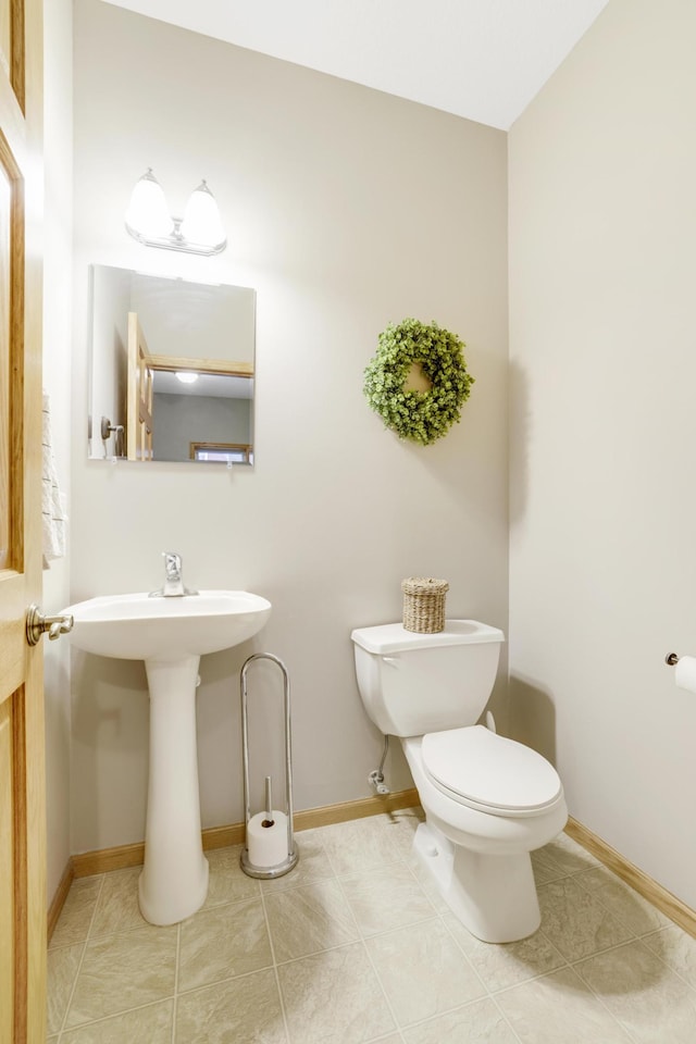 562 Hillside Dr, Prescott, WI 54021 - half bath featuring toilet, baseboards, tile patterned flooring, and a sink