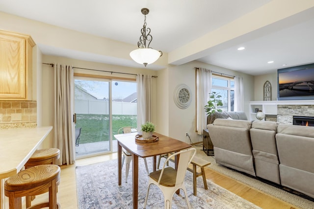562 Hillside Dr, Prescott, WI 54021 - dining room featuring light wood-style flooring, recessed lighting, and a fireplace