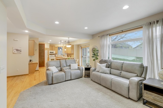 562 Hillside Dr, Prescott, WI 54021 - living room featuring recessed lighting, light wood-type flooring, a chandelier, and baseboards