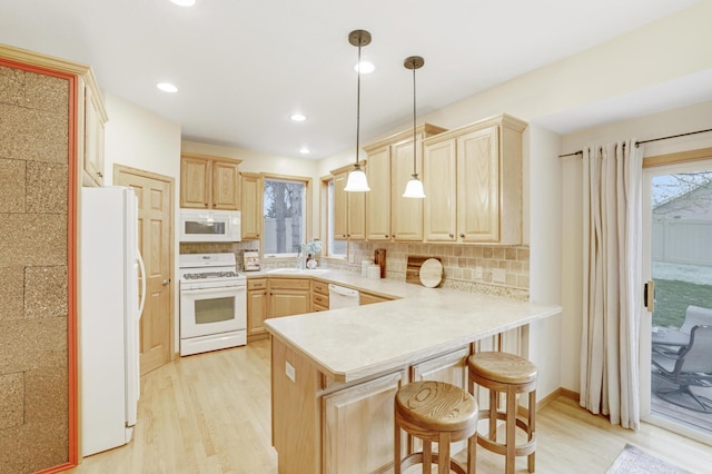 562 Hillside Dr, Prescott, WI 54021 - kitchen featuring white appliances, light brown cabinets, a peninsula, light wood-type flooring, and recessed lighting