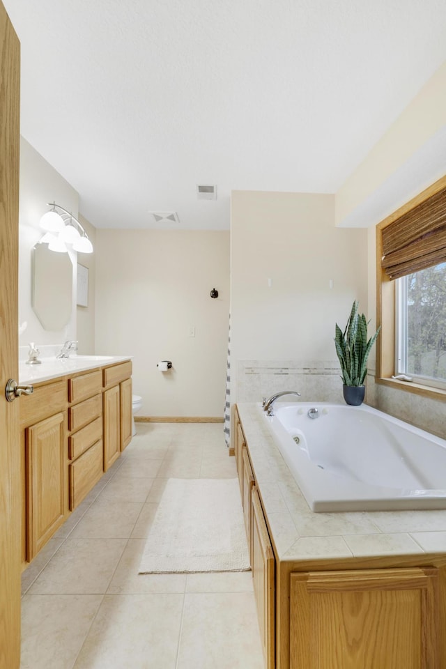 562 Hillside Dr, Prescott, WI 54021 - full bathroom with tile patterned floors, vanity, a whirlpool tub, toilet, and baseboards