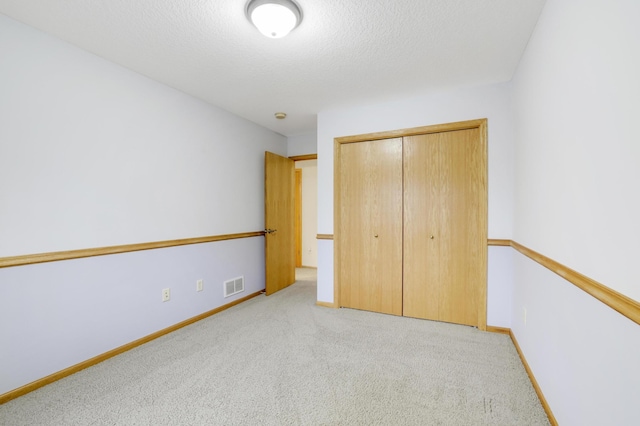 562 Hillside Dr, Prescott, WI 54021 - unfurnished bedroom with carpet floors, a closet, a textured ceiling, and baseboards
