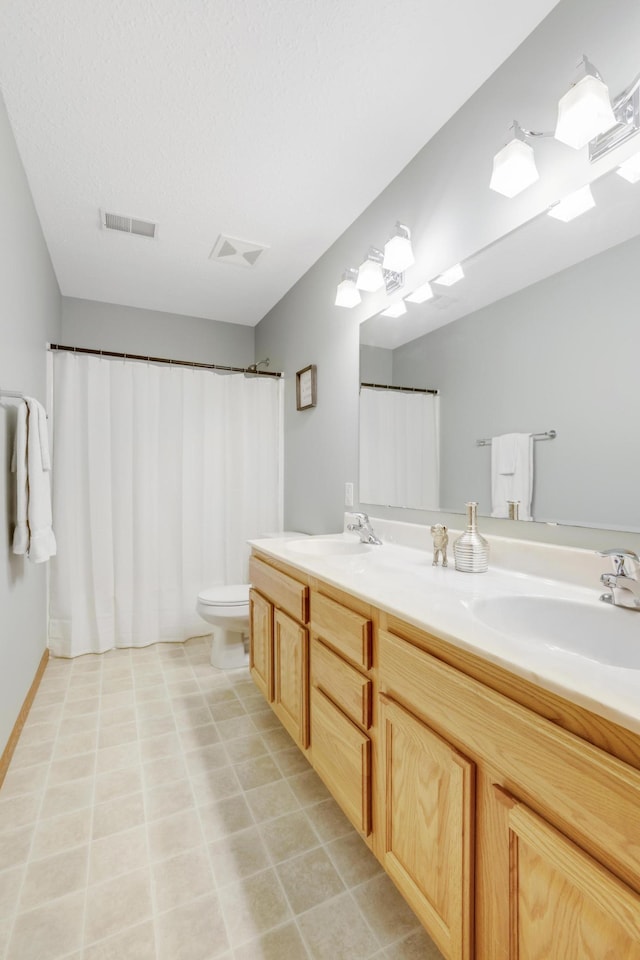 562 Hillside Dr, Prescott, WI 54021 - bathroom featuring double vanity, toilet, and tile patterned flooring