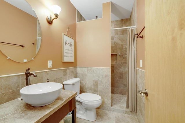 562 Hillside Dr, Prescott, WI 54021 - bathroom with tile walls, tiled shower, a wainscoted wall, toilet, and vanity