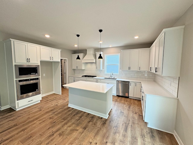 14234 Empire Ln N, Dayton, MN 55327 - kitchen featuring stainless steel appliances, custom exhaust hood, a sink, tasteful backsplash, and white cabinetry