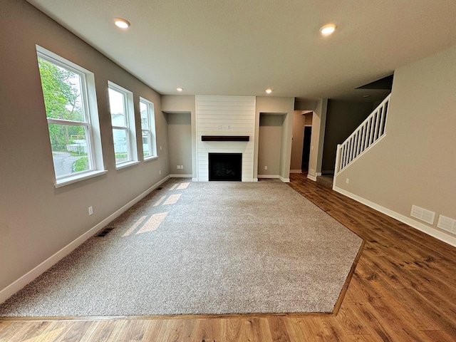 14234 Empire Ln N, Dayton, MN 55327 - unfurnished living room featuring baseboards, stairs, a fireplace, recessed lighting, and wood finished floors