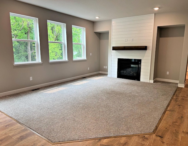 14234 Empire Ln N, Dayton, MN 55327 - unfurnished living room featuring baseboards, a fireplace, recessed lighting, and wood finished floors