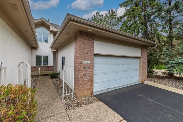 5541 70th St, Edina, MN 55439 - view of property exterior with driveway, brick siding, stucco siding, and an attached garage