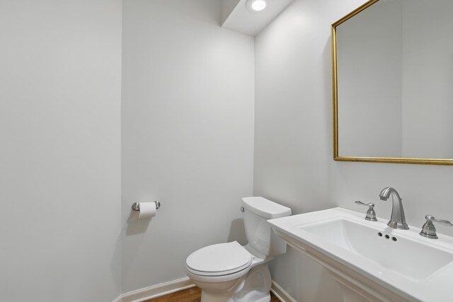 5541 70th St, Edina, MN 55439 - bathroom featuring toilet, a sink, baseboards, and wood finished floors