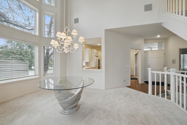 5541 70th St, Edina, MN 55439 - carpeted dining room featuring a high ceiling, baseboards, a chandelier, and a sink
