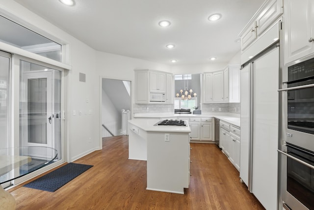 5541 70th St, Edina, MN 55439 - kitchen featuring white microwave, white cabinetry, light countertops, wood finished floors, and recessed lighting