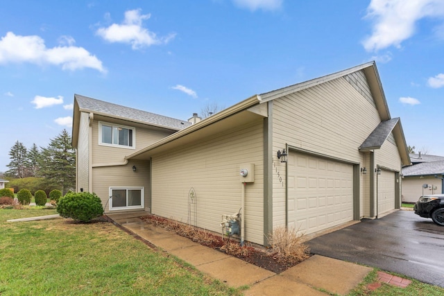 view of side of home with driveway, a yard, and an attached garage