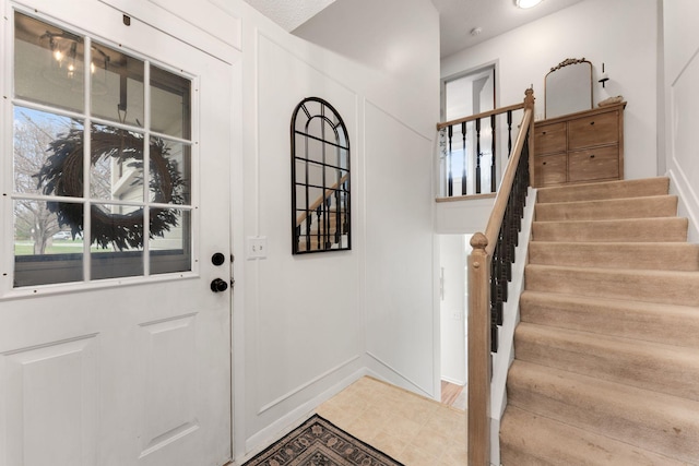 interior space featuring stairs, baseboards, and plenty of natural light