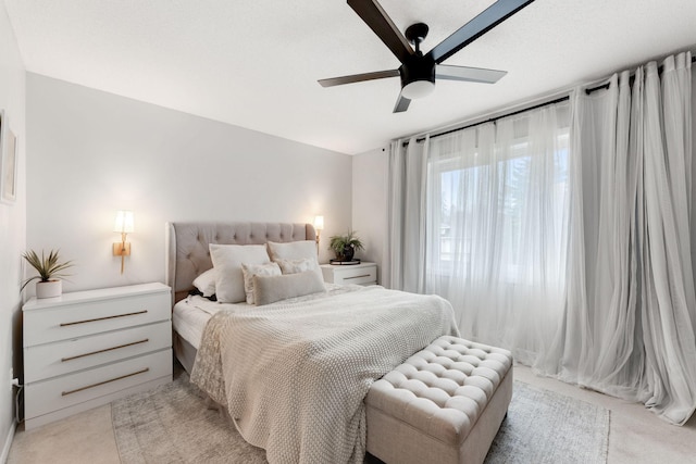 bedroom with a ceiling fan and light carpet