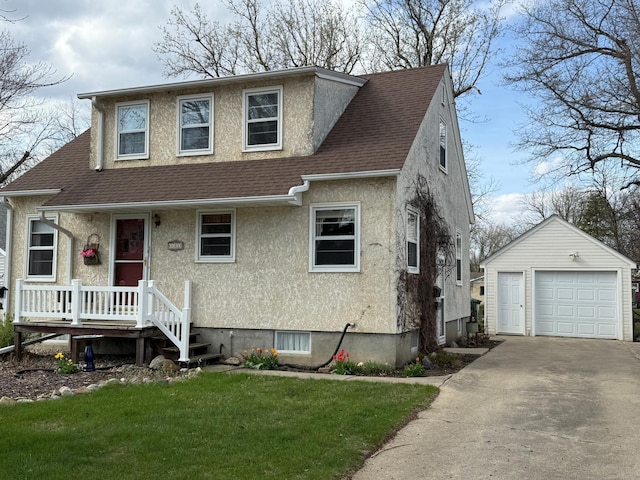 bungalow with an outdoor structure, a detached garage, a shingled roof, a front yard, and stucco siding
