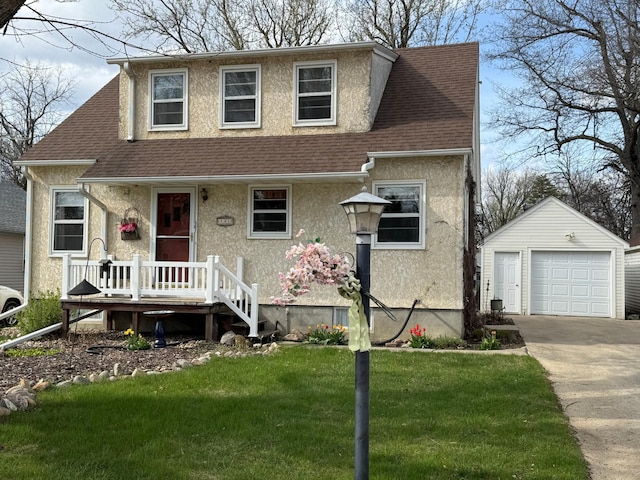 view of front facade featuring stucco siding, roof with shingles, a front yard, and an outbuilding