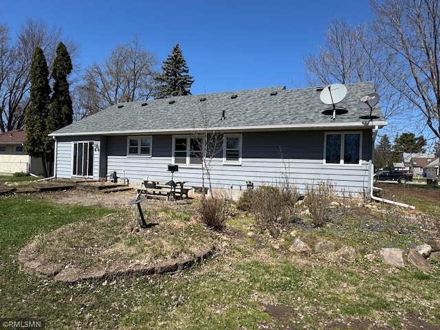 rear view of house with roof with shingles