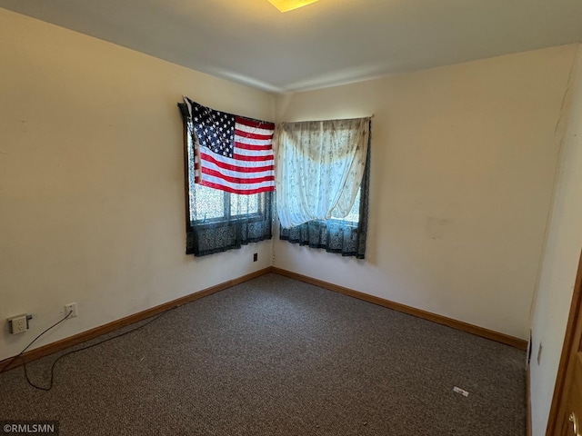 carpeted empty room with baseboards