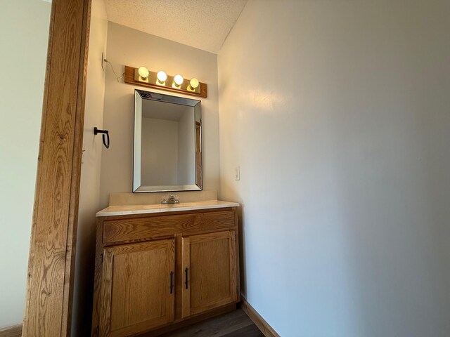 bathroom featuring wood finished floors, a textured ceiling, and vanity