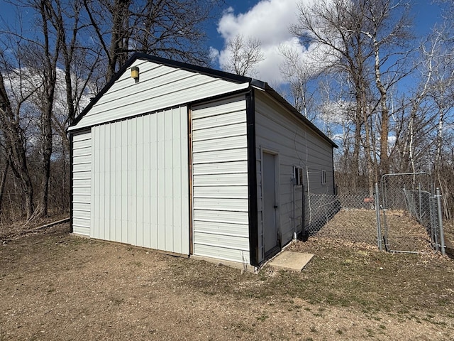 view of outbuilding featuring fence and an outbuilding
