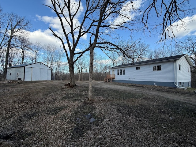 view of yard featuring a detached garage and an outbuilding