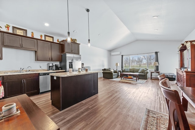 kitchen with dark brown cabinetry, appliances with stainless steel finishes, vaulted ceiling, and a wall mounted air conditioner