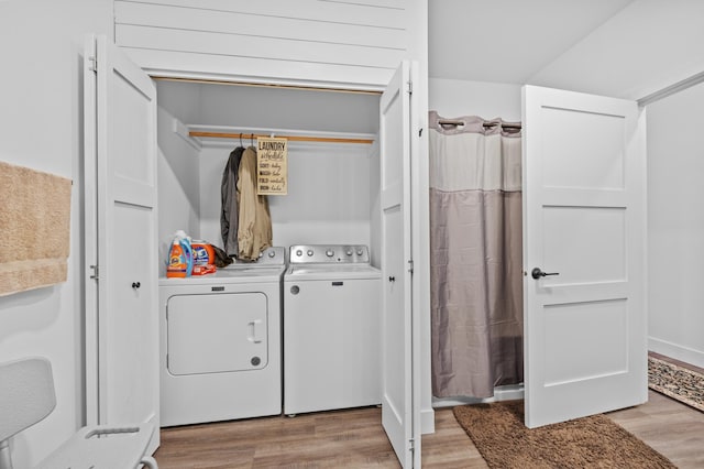 clothes washing area with light wood-style floors, laundry area, and independent washer and dryer