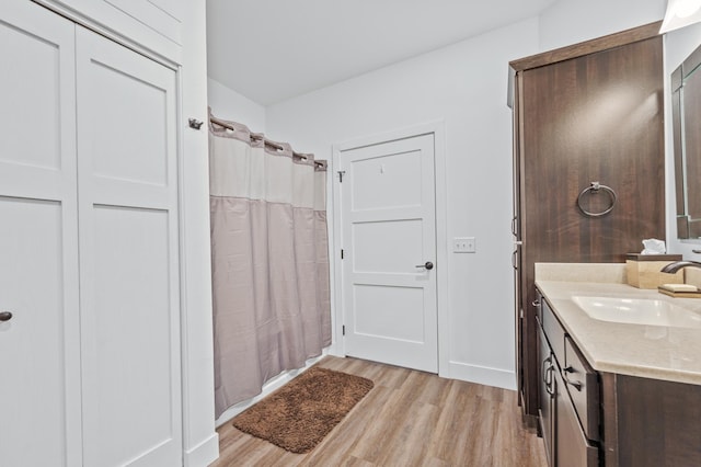 bathroom with vanity, curtained shower, and wood finished floors