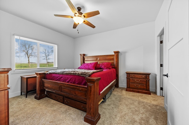 carpeted bedroom with ceiling fan and baseboards