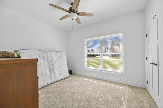 carpeted bedroom featuring a ceiling fan and baseboards