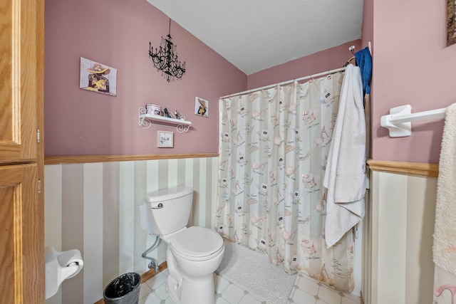 26294 3rd St W, Zimmerman, MN 55398 - bathroom with a textured ceiling, toilet, a wainscoted wall, and a shower with shower curtain