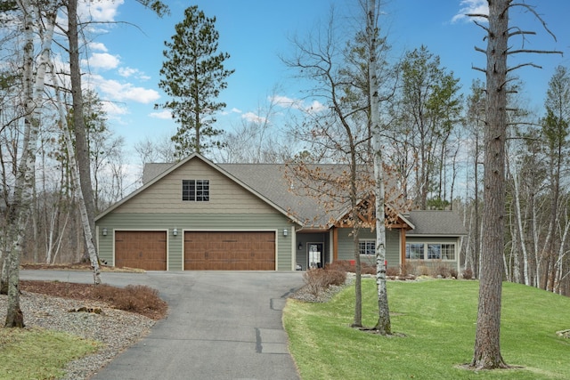 view of front facade with driveway, a front yard, a shingled roof, and an attached garage