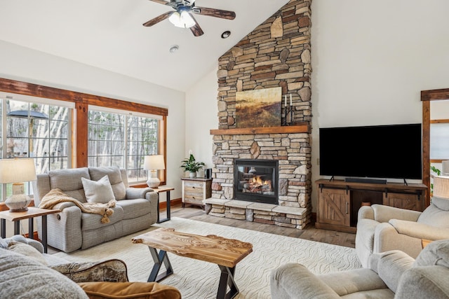 living area with a ceiling fan, high vaulted ceiling, wood finished floors, and a fireplace