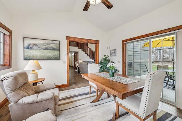 dining area featuring stairway, wood finished floors, lofted ceiling, and plenty of natural light
