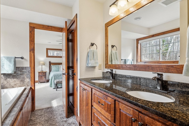 full bath with visible vents, double vanity, ensuite bathroom, and a sink