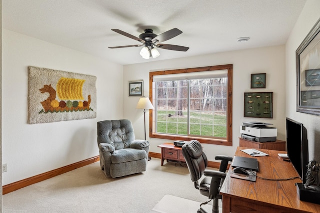 carpeted office featuring baseboards and ceiling fan