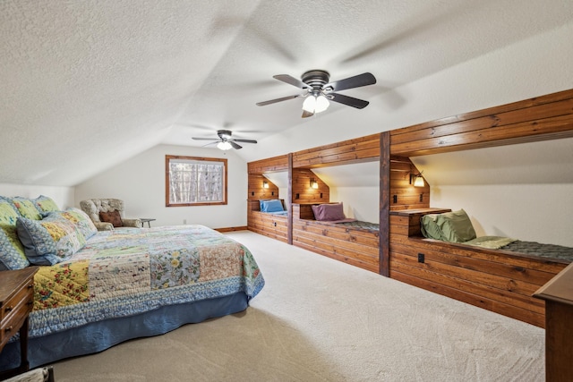 carpeted bedroom featuring a textured ceiling, a ceiling fan, and lofted ceiling