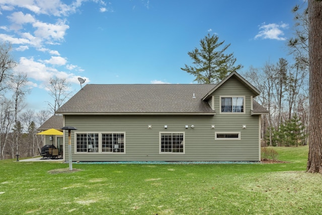 back of property featuring a patio, a yard, and a shingled roof