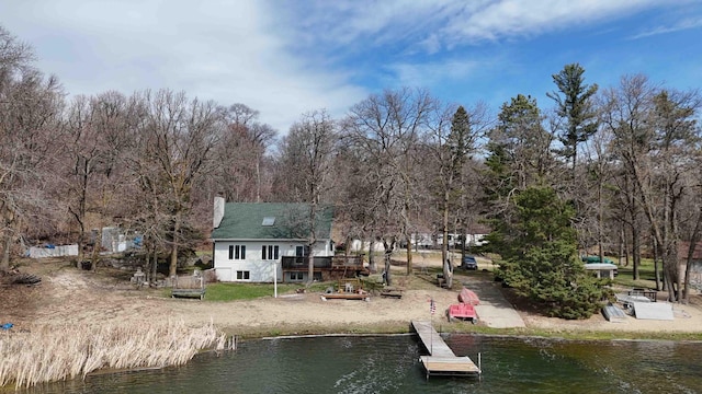 34470 Spruce Ln, Pequot Lakes, MN 56472 - rear view of house with a chimney, a deck with water view, and view of scattered trees