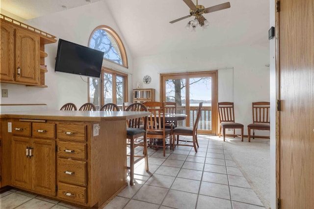 34470 Spruce Ln, Pequot Lakes, MN 56472 - kitchen featuring high vaulted ceiling, plenty of natural light, ceiling fan, a kitchen breakfast bar, and brown cabinetry