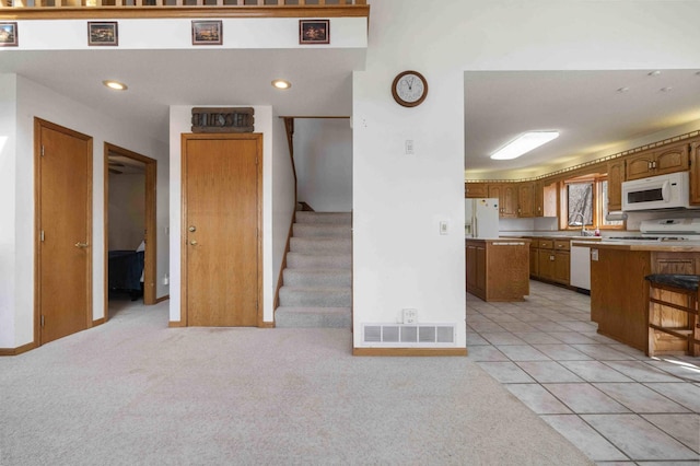 34470 Spruce Ln, Pequot Lakes, MN 56472 - kitchen featuring white appliances, light colored carpet, brown cabinetry, and recessed lighting