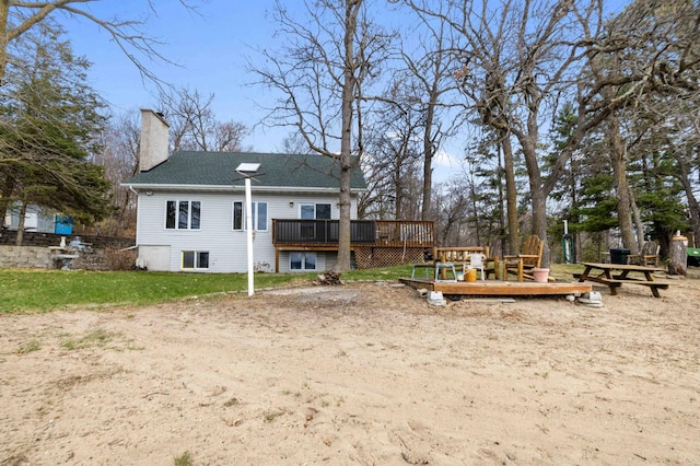34470 Spruce Ln, Pequot Lakes, MN 56472 - back of property with a deck, a chimney, a shingled roof, and a yard