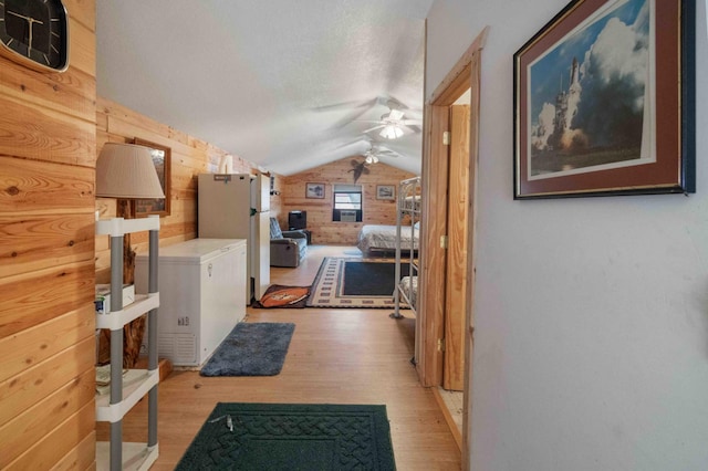 34470 Spruce Ln, Pequot Lakes, MN 56472 - hall featuring lofted ceiling, wooden walls, light wood finished floors, and a textured ceiling