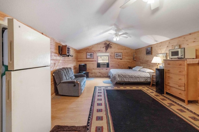 34470 Spruce Ln, Pequot Lakes, MN 56472 - bedroom featuring freestanding refrigerator, wood walls, lofted ceiling, wood finished floors, and ceiling fan