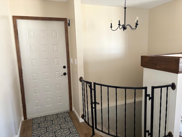 doorway to outside with baseboards, a chandelier, and wood finished floors