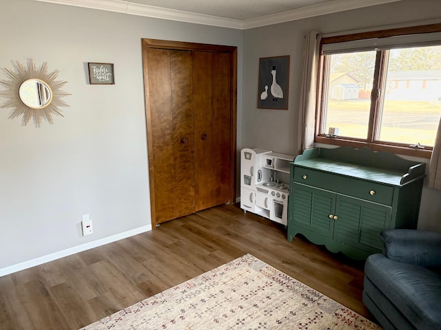 sitting room featuring crown molding, baseboards, and wood finished floors