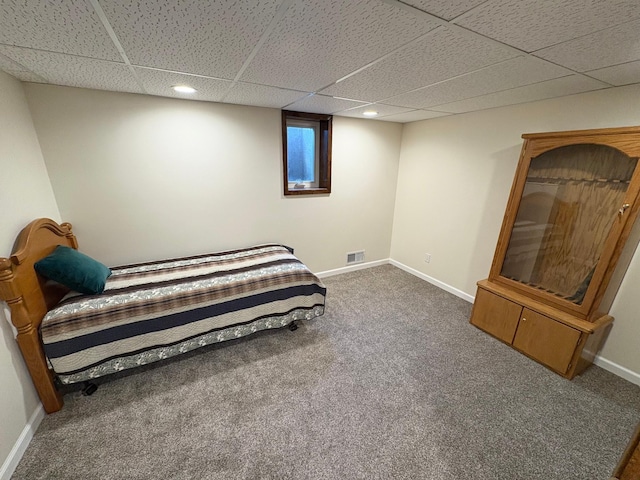 bedroom featuring baseboards, a drop ceiling, carpet flooring, and visible vents